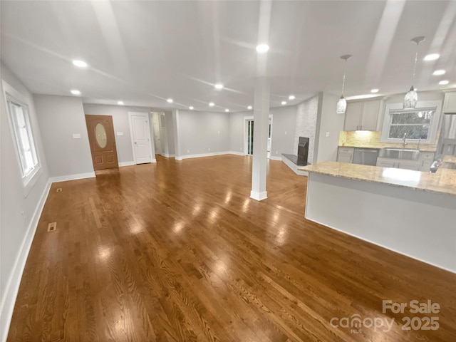 unfurnished living room with sink, a fireplace, and hardwood / wood-style floors