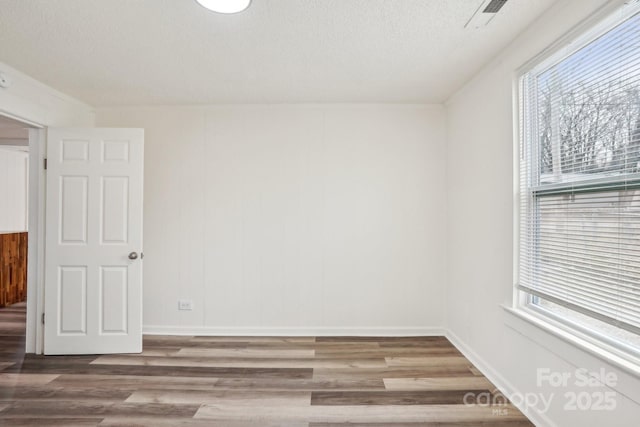 spare room with wood-type flooring and a textured ceiling