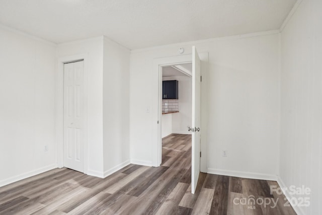 empty room with hardwood / wood-style flooring and ornamental molding