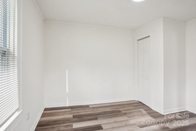 empty room featuring ornamental molding and hardwood / wood-style floors