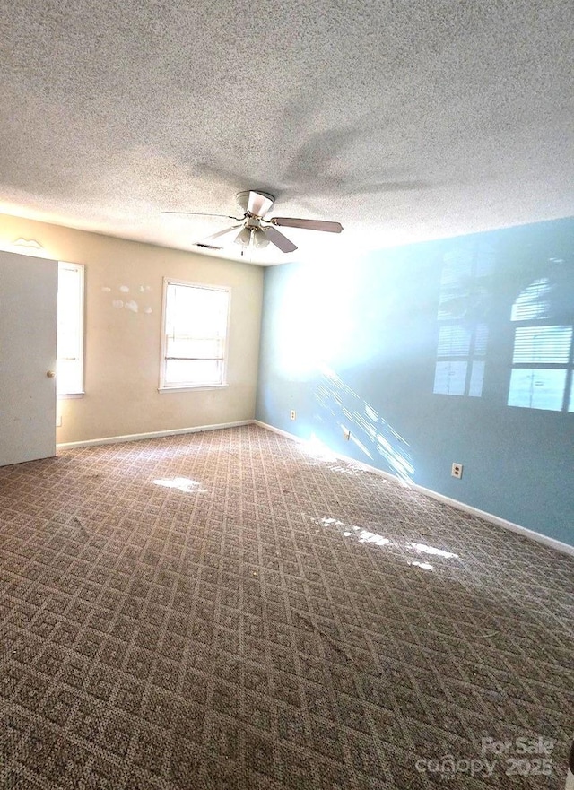 carpeted empty room featuring ceiling fan and a textured ceiling