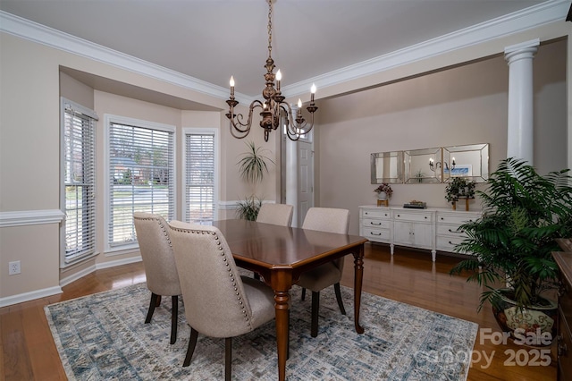 dining area with crown molding, wood finished floors, baseboards, and ornate columns