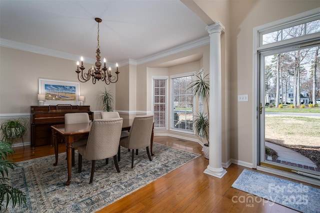 dining room featuring plenty of natural light, ornate columns, and hardwood / wood-style flooring