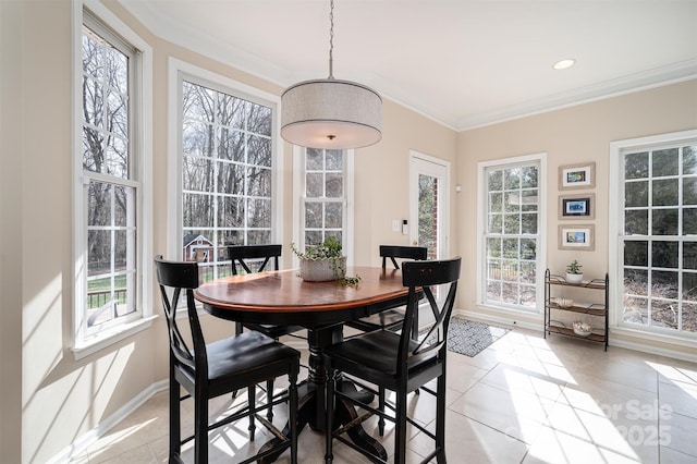 dining space with baseboards, a healthy amount of sunlight, ornamental molding, and light tile patterned flooring