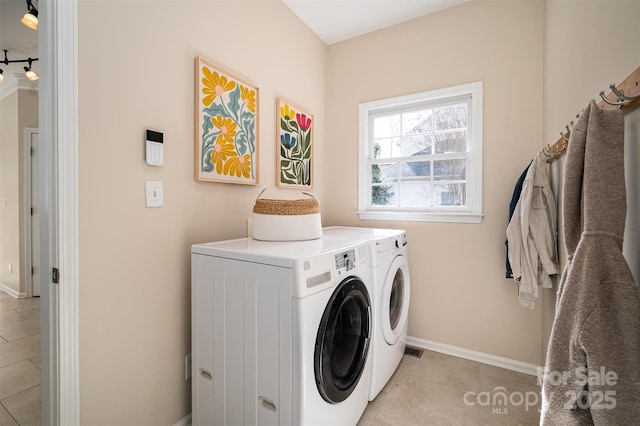 laundry room featuring light tile patterned floors, baseboards, laundry area, and washing machine and clothes dryer