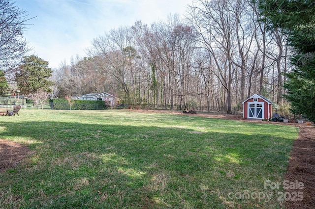 view of yard with a storage unit, an outbuilding, and a fenced backyard