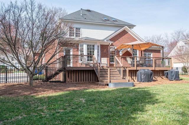 rear view of property with brick siding, a lawn, a deck, and fence