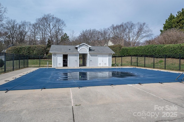 pool featuring a patio area, fence, and an outdoor structure