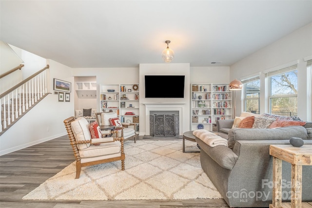 living room with wood-type flooring and built in features