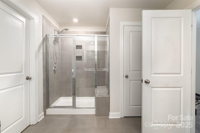 bathroom with tile patterned flooring and a shower with door