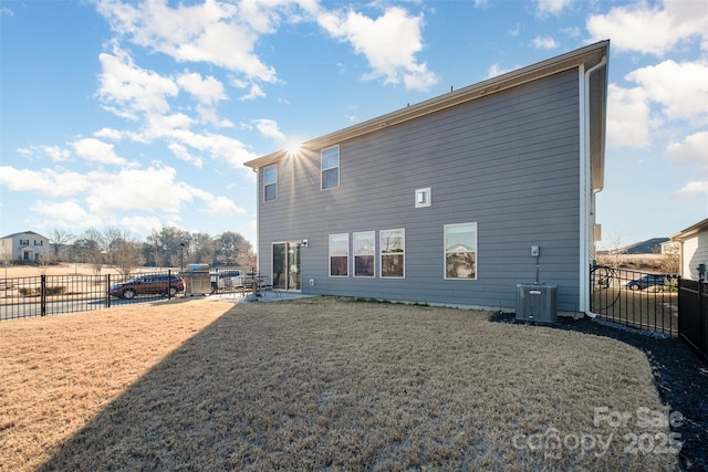 back of house featuring a lawn, central air condition unit, and a patio area