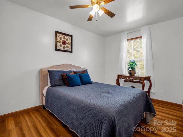 bedroom with ceiling fan and dark hardwood / wood-style flooring