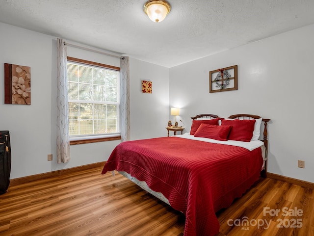 bedroom with wood-type flooring and a textured ceiling