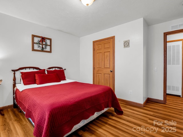 bedroom with hardwood / wood-style flooring and a textured ceiling