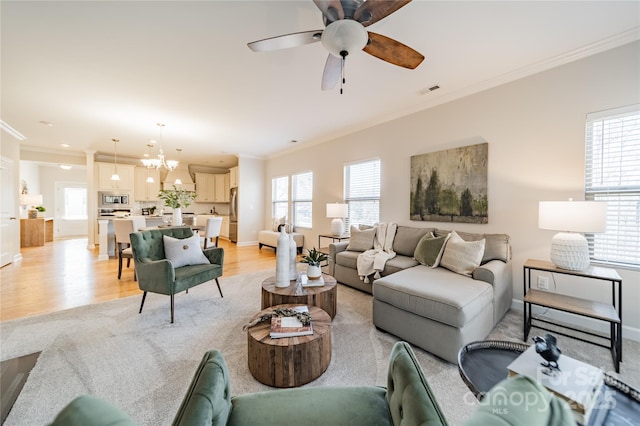 living room with ornamental molding, plenty of natural light, and light hardwood / wood-style floors