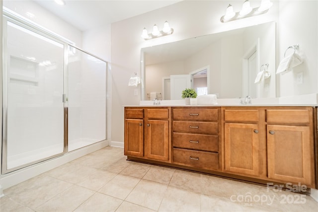 bathroom featuring vanity, a shower with shower door, and tile patterned flooring