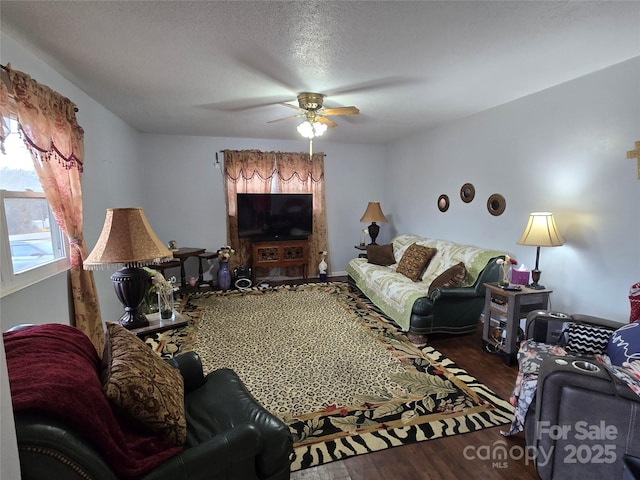 living room with hardwood / wood-style flooring, ceiling fan, and a textured ceiling