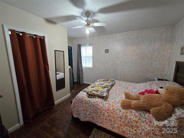 bedroom featuring ceiling fan, dark hardwood / wood-style floors, and a textured ceiling