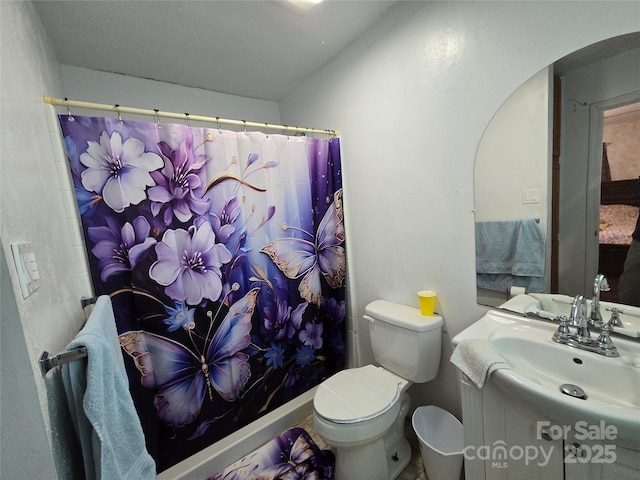 bathroom featuring a shower with curtain, vanity, and toilet