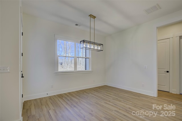 unfurnished dining area featuring a notable chandelier and light wood-type flooring