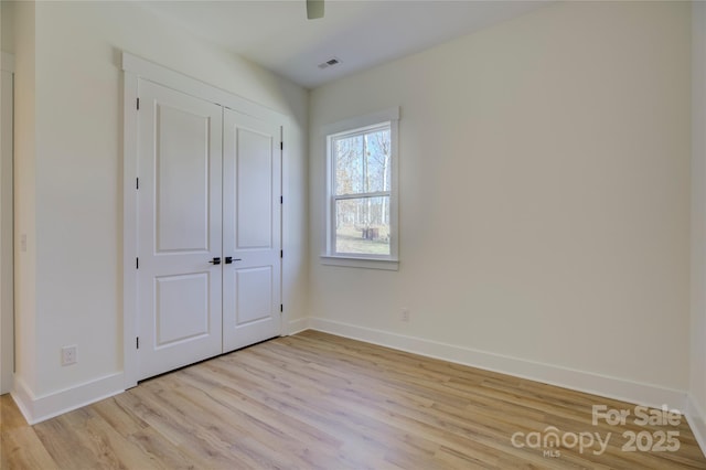 unfurnished bedroom featuring a closet, ceiling fan, and light wood-type flooring