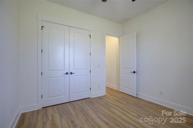 unfurnished bedroom featuring light wood-type flooring and a closet