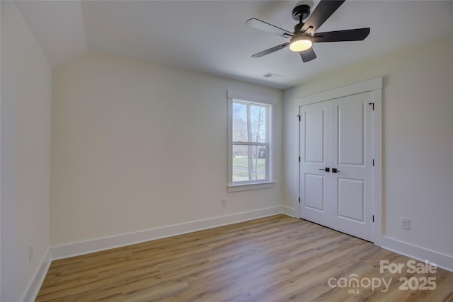 unfurnished bedroom with ceiling fan, a closet, and light wood-type flooring