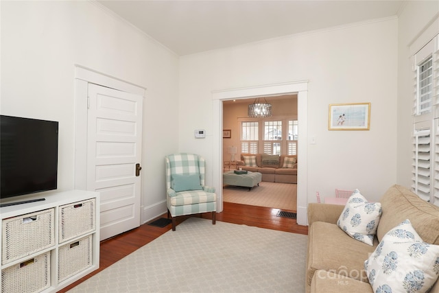 living room featuring ornamental molding, dark hardwood / wood-style floors, and a notable chandelier