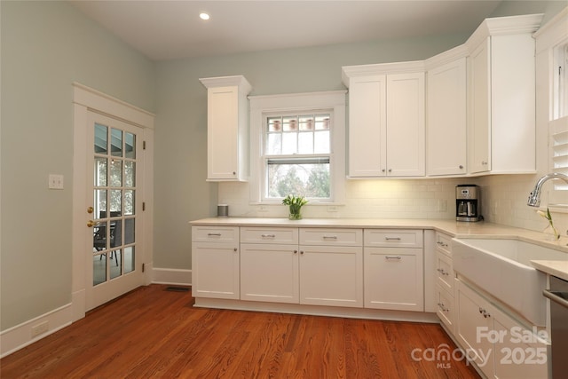 kitchen with tasteful backsplash, sink, white cabinets, and dark hardwood / wood-style flooring