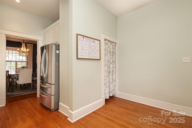 hallway with hardwood / wood-style floors and a chandelier