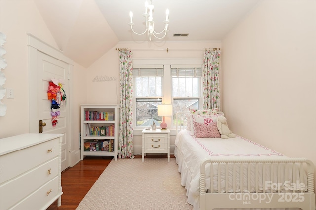 bedroom with dark wood-type flooring, a chandelier, and vaulted ceiling