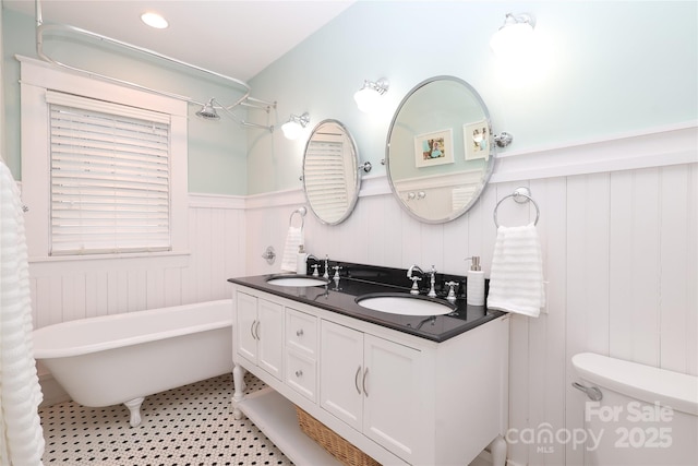 bathroom with vanity, a bath, and toilet