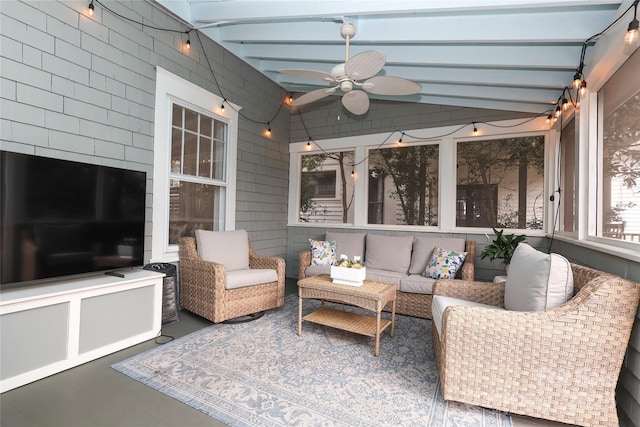 sunroom featuring ceiling fan and vaulted ceiling with beams