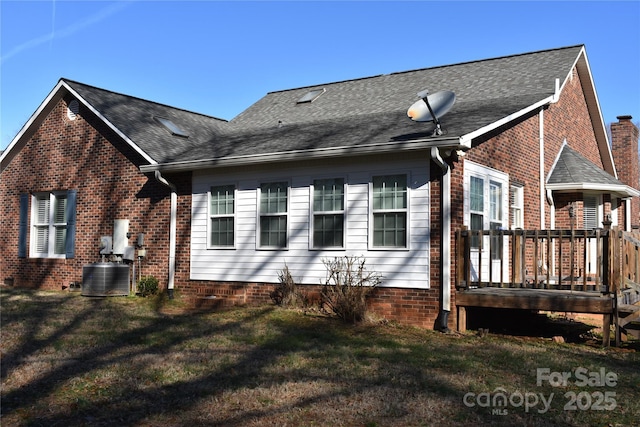 view of side of home featuring cooling unit, a deck, and a lawn