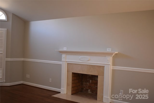 unfurnished living room featuring vaulted ceiling, dark wood-type flooring, and a fireplace