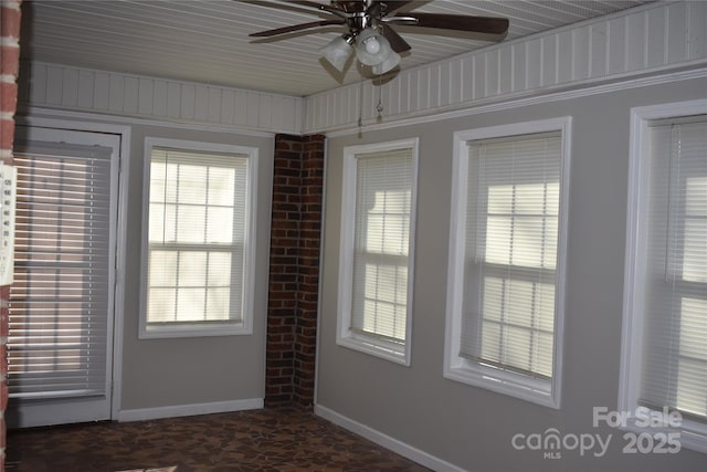 unfurnished sunroom with ceiling fan