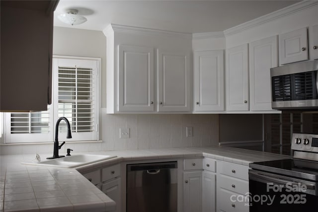 kitchen with white cabinetry, stainless steel appliances, and tile counters