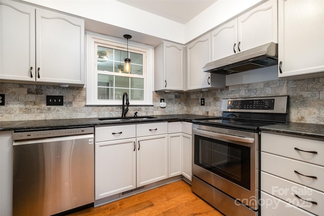 kitchen featuring visible vents, light wood-style flooring, appliances with stainless steel finishes, a sink, and under cabinet range hood