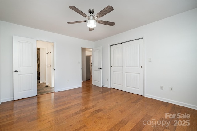 unfurnished bedroom featuring a closet, ceiling fan, baseboards, and wood finished floors