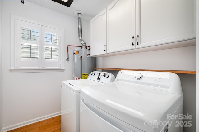 washroom with water heater, cabinet space, light wood-style floors, washing machine and dryer, and baseboards