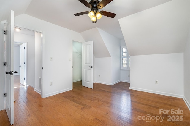 bonus room with baseboards, vaulted ceiling, light wood finished floors, and ceiling fan