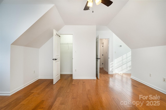 bonus room with vaulted ceiling, baseboards, and wood finished floors