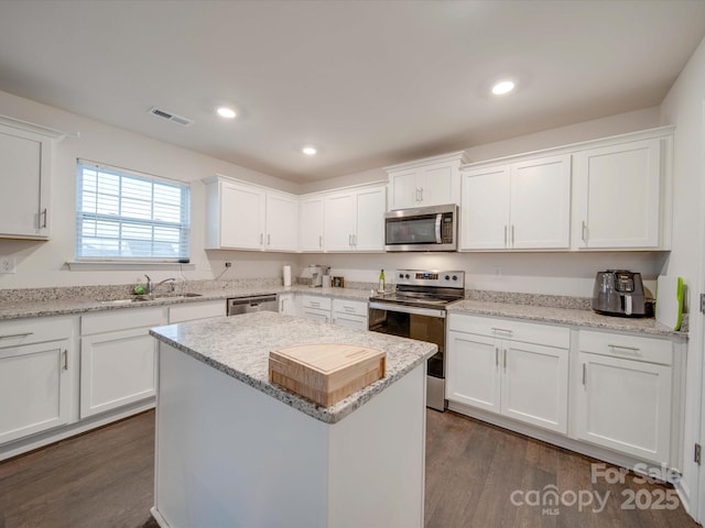 kitchen featuring sink, white cabinetry, dark hardwood / wood-style floors, a kitchen island, and stainless steel appliances