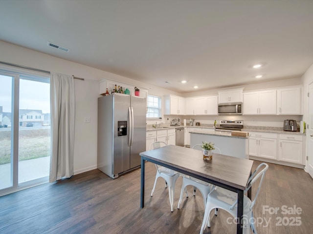 kitchen with white cabinetry, dark hardwood / wood-style flooring, and appliances with stainless steel finishes