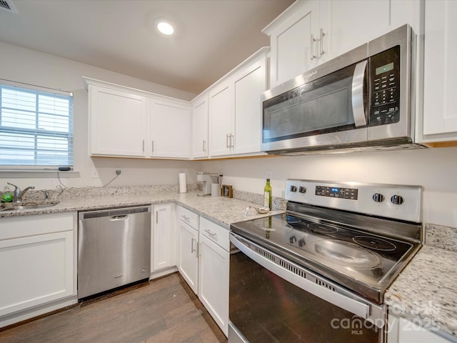 kitchen featuring appliances with stainless steel finishes, sink, dark wood-type flooring, and white cabinets