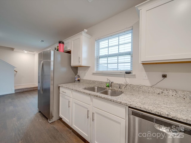 kitchen with dark wood-type flooring, sink, white cabinetry, light stone counters, and stainless steel appliances