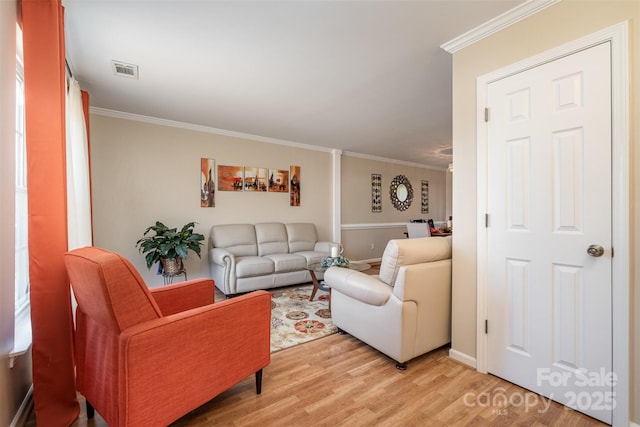 living room with light hardwood / wood-style flooring and ornamental molding