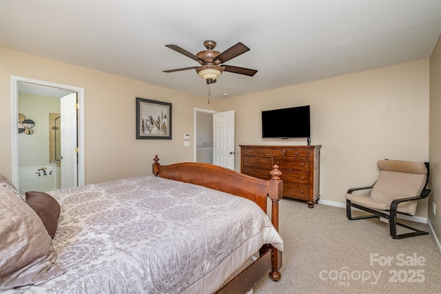 bedroom with ensuite bathroom, light carpet, and ceiling fan