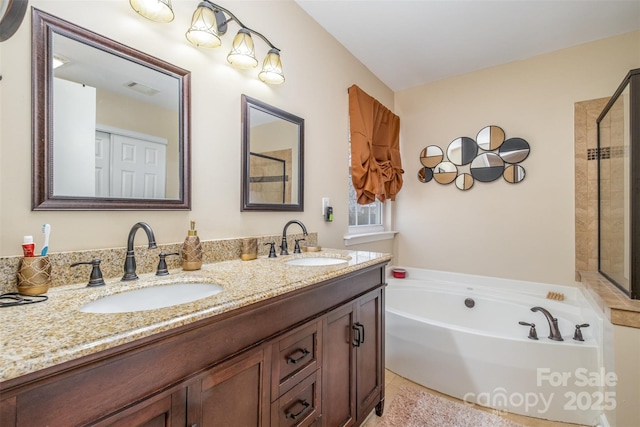 bathroom featuring vanity and independent shower and bath