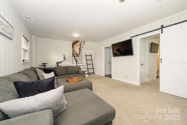 living room with light carpet and a barn door